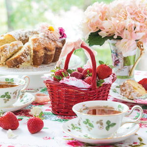 Cake, tea, basket, and flowers on a spring table Featured In Southern Lady Southern Cottage 2022