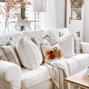 white room with white couch throw and pillows