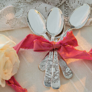 silver spoons with red ribbon