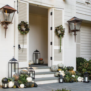 pumpkins and lanterns on front porch of home
