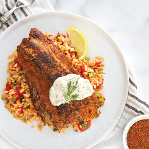 red fish over rice on white plate