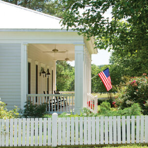 fenced in front porch with american flag
