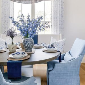 Wood dining table with blue chairs and tablescape