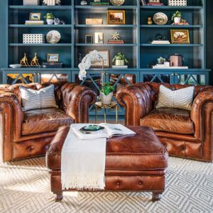 brown leather chairs in front of blue built in shelving