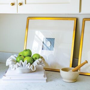 Gold frames and books on kitchen counter