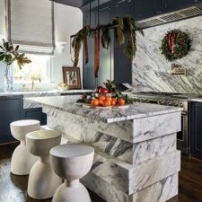 Kitchen with marble counters and stools