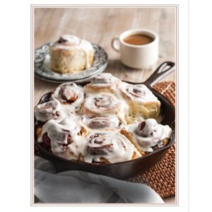 Growing Up Cajun Expanded 2025 featuring cinnamon rolls in cast iron skillet