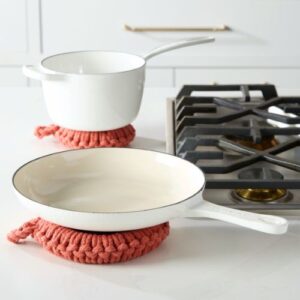 clay crocheted trivet set on kitchen counter with enamel cookware
