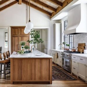 Southern Home May_June 2025 featuring kitchen with wood island and white cabinets/ vent hood