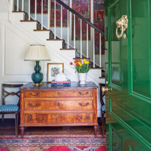 A green lacquered door adds a punch of color to the inviting foyer.