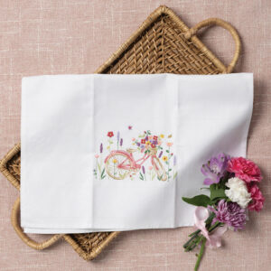 White tea towel with embroidered pink bicycle