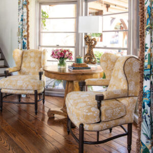 Sitting area with taupe arm chairs and flower display