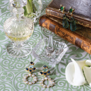 Green and white tablecloth with earrings books, and flower petals