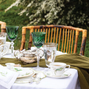 Place setting with green accents, tea, and crystal