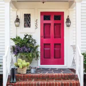 Front step with pinkish/red door and plants