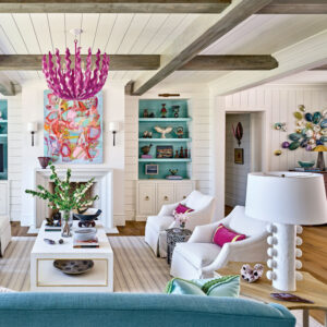 Sitting area with pink chandelier, white chairs, and blue accents