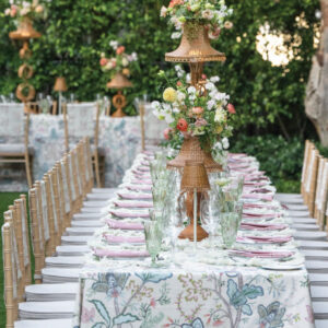 Spring table setting with floral table cloth and gold chairs