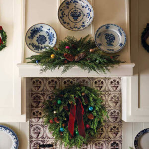 Christmas wreath above stove with blue and white plates