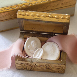 Emblems in wooden box and pink ribbon