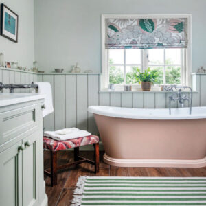 Bathroom with stripe rug and pink bathtub