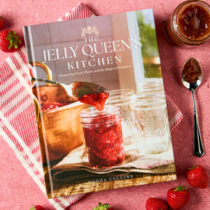 Jelly Queen's styled cover with jam, strawberries, and linen napkin