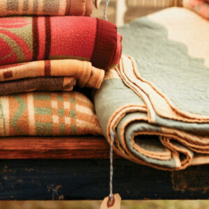 Wool blankets sitting on a bench folded