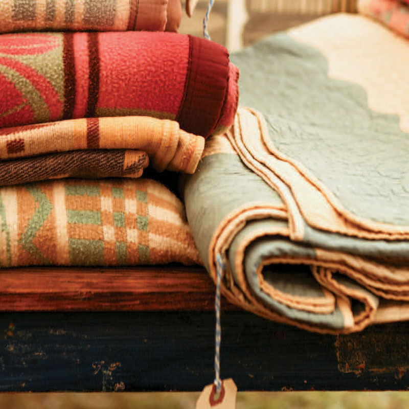 Wool blankets sitting on a bench folded