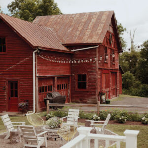 Maroon farm house with string lights and outdoor seating
