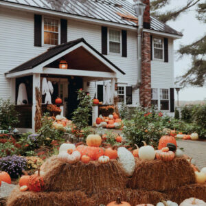 Front of house decorated with hay bails and pumpkins