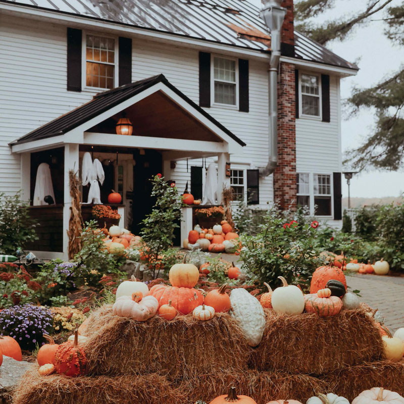 Front of house decorated with hay bails and pumpkins