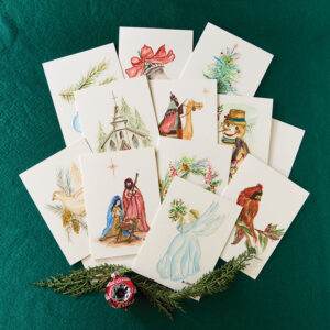 Holiday notecards on green fabric with holly and ornament