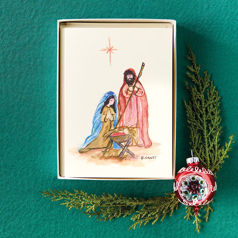 Holiday notecards on green fabric with holly and ornament